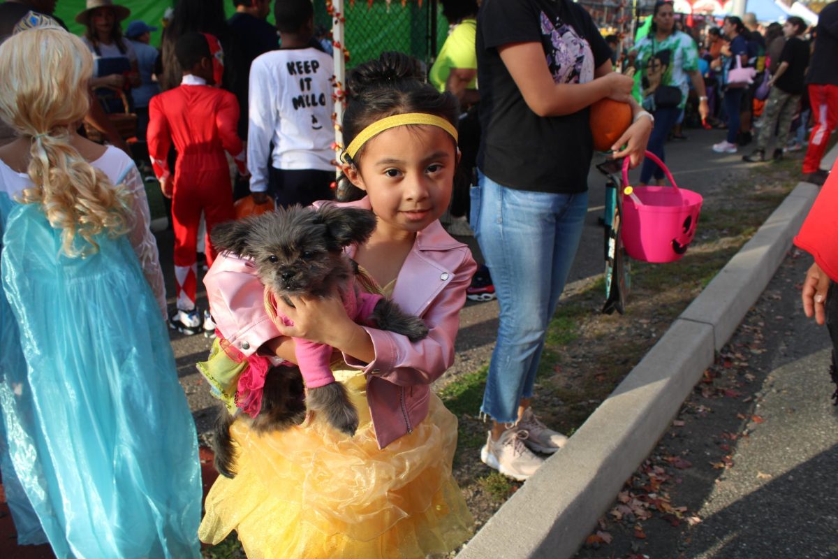 Girl dressed up as belle with her dog also in a costume. 