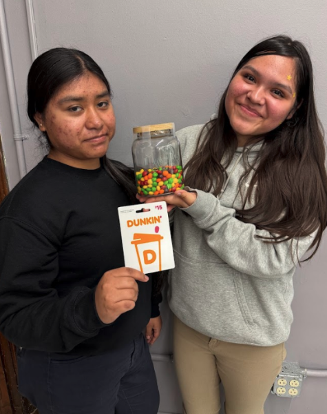 Yulisa Flores, left, is awarded a $15 gift card from contest creator Yamilet Gonzalez, right.